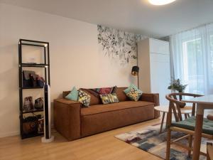 a living room with a brown couch and a table at NOVERA Apartments #24 in Turčianske Teplice