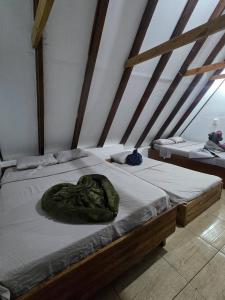 a bed with a green blanket on top of it at private and pleasant in Zapotal
