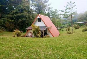 a small house with a red roof in a field at private and pleasant in Zapotal