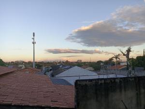 a view of a city with roofs and a cloudy sky at Estúdio 800m do Buriti Shopping in Aparecida de Goiânia