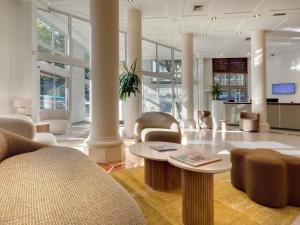 a lobby with chairs and a table in a building at Mercure Montpellier Centre Antigone in Montpellier