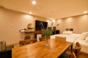 a living room with a bed and a table with flowers on it at 경산 에비앙 호텔 in Uksu