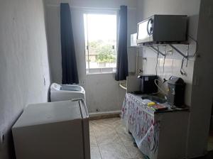 a small room with a television on top of a refrigerator at Estúdio 800m do Buriti Shopping in Aparecida de Goiânia