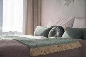 a bedroom with a bed with pillows and a window at NOVERA Apartments #24 in Turčianske Teplice