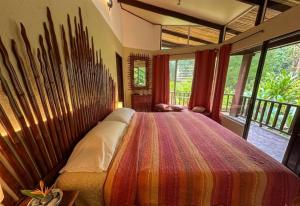 a bedroom with a large bed with a colorful blanket at Heliconia Island Lodge in Puerto Viejo