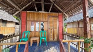 two chairs and a table on the porch of a house at Saubaryam Home stay in Fam