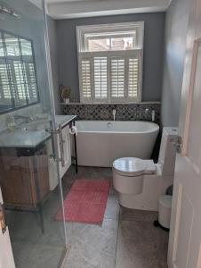 a bathroom with a tub and a toilet and a sink at Rusthall Prospect House in Speldhurst