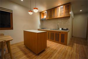 a kitchen with wooden cabinets and a counter top at Ikigai Narvacan Hometel in Narvacan