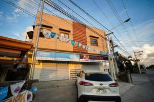 a white car parked in front of a building at Ikigai Narvacan Hometel in Narvacan