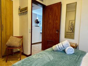 a bedroom with a bed and a chair and a door at Remodeled Margarita Apt Pool in Porlamar
