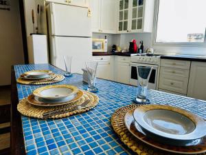 a kitchen with a table with plates and glasses on it at Remodeled Margarita Apt Pool in Porlamar +4 photos