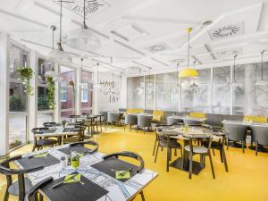 a restaurant with tables and chairs in a room at Ibis Styles Budapest City in Budapest