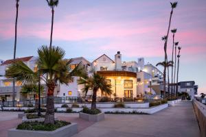 a building with palm trees in front of it at Sandcastle Hotel on the Beach in Pismo Beach