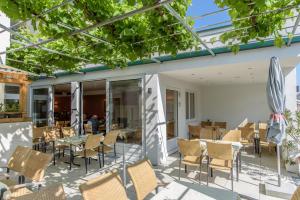 zewnętrzne patio z krzesłami i stołami oraz budynek w obiekcie Hotel Zachs w mieście Sankt Margarethen im Burgenland
