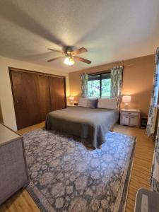 a bedroom with a bed with a ceiling fan and a rug at Hale Mauna Loa Upper Level with shared Hot Tub in Volcano