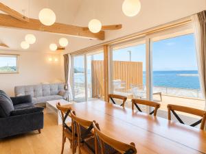a living room with a large wooden table and chairs at Beach SPA TSUDA 0 Cero棟 in Sanuki