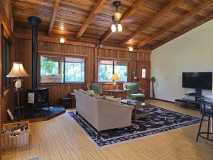 a living room with a couch and a tv at Hale Mauna Loa Upper Level with shared Hot Tub in Volcano