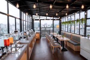 a restaurant with tables and chairs and windows at The Cozy Hotel in Ho Chi Minh City