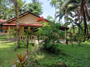 a house with palm trees in front of it at Lake View Bungalows in Khao Lak