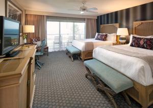 a hotel room with two beds and a flat screen tv at Spyglass Inn in Pismo Beach +36 photos