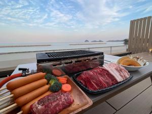 a barbecue grill with meat and vegetables on a table at Beach SPA TSUDA 0 Cero棟 in Sanuki