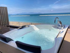 a jacuzzi tub with a view of the ocean at Beach SPA TSUDA 0 Cero棟 in Sanuki