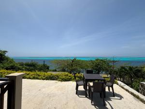 a table and chairs on a balcony with the ocean at Ocean Inn- Sector el Bluff in Bottom House
