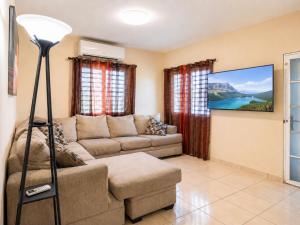 a living room with a couch and a flat screen tv at Arenales Guest House in Isabela