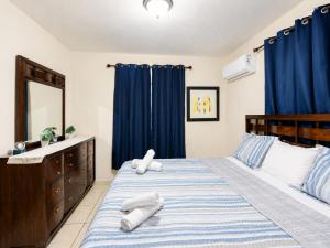 a bedroom with a large bed with blue curtains at Arenales Guest House in Isabela