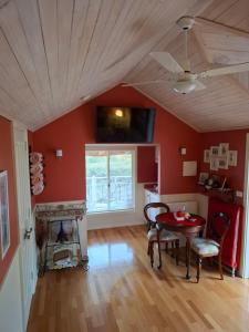 a living room with red walls and a table and chairs at Bella Rouge Cottage in Bright