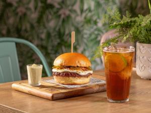 a sandwich on a wooden tray next to a drink at Mercure São Paulo Berrini in São Paulo
