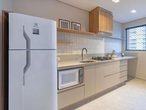 a kitchen with a white refrigerator and a microwave at Mercure São Paulo Berrini in São Paulo