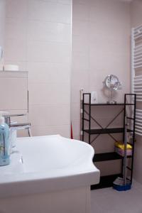 a white bathroom with a sink and a shelf at T&M Apartman Premium 2 in Paraćin