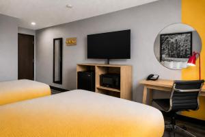 a hotel room with two beds and a flat screen tv at Super 8 by Wyndham Champaign in Champaign