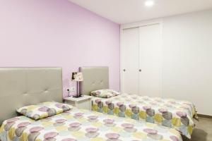 2 camas en un dormitorio con paredes rosas en Amazing sea view in Los Cristianos, en Los Cristianos