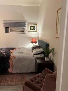 a bedroom with a bed and a table and a couch at Cozy Home in Flin Flon