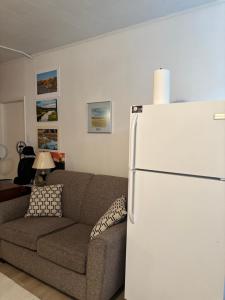 a living room with a couch and a white refrigerator at Cozy Home in Flin Flon