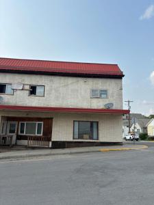 a building with a red roof on a street at Cozy Home in Flin Flon