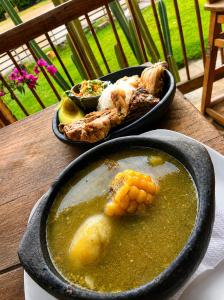 a table with two bowls of soup and a plate of food at El Caney Experiences in Armenia