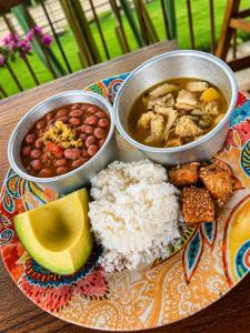 a plate of food with rice and bowls of food at El Caney Experiences in Armenia