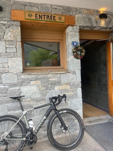a bike parked in front of a stone building at Chalet Hotel Alpaka in Châtel +16 photos