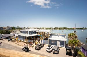 a house with cars parked in front of a marina at The Silver Lake Hotel at Ocracoke in Ocracoke