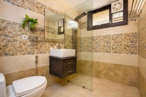 a bathroom with a toilet and a sink and a shower at Ramashray - Mud House Living in Haldwāni +7 photos