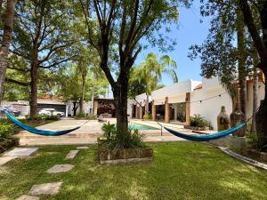 two hammocks hanging from a tree in front of a house at Quinta Encanto in Santiago Nuevo León in Santiago