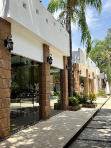 a building with glass doors and palm trees at Quinta Encanto in Santiago Nuevo León in Santiago