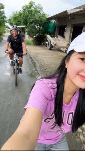 two people riding a bike down a street at Que Nha Homestay in Ấp Chợ (2)