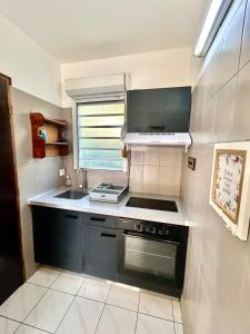 a small kitchen with a stove and a sink at Aqua vista appartement in Le Marin
