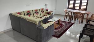 a living room with a couch and a table at Ithal Villa - Home Stay in Wayanad