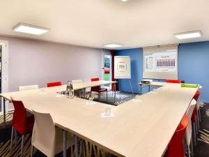 a conference room with a long table and chairs at ibis Brest Kergaradec in Brest