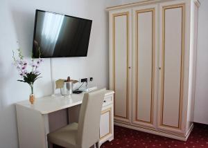 Pokój z biurkiem i telewizorem na ścianie w obiekcie Hotel Centrale w mieście Piombino